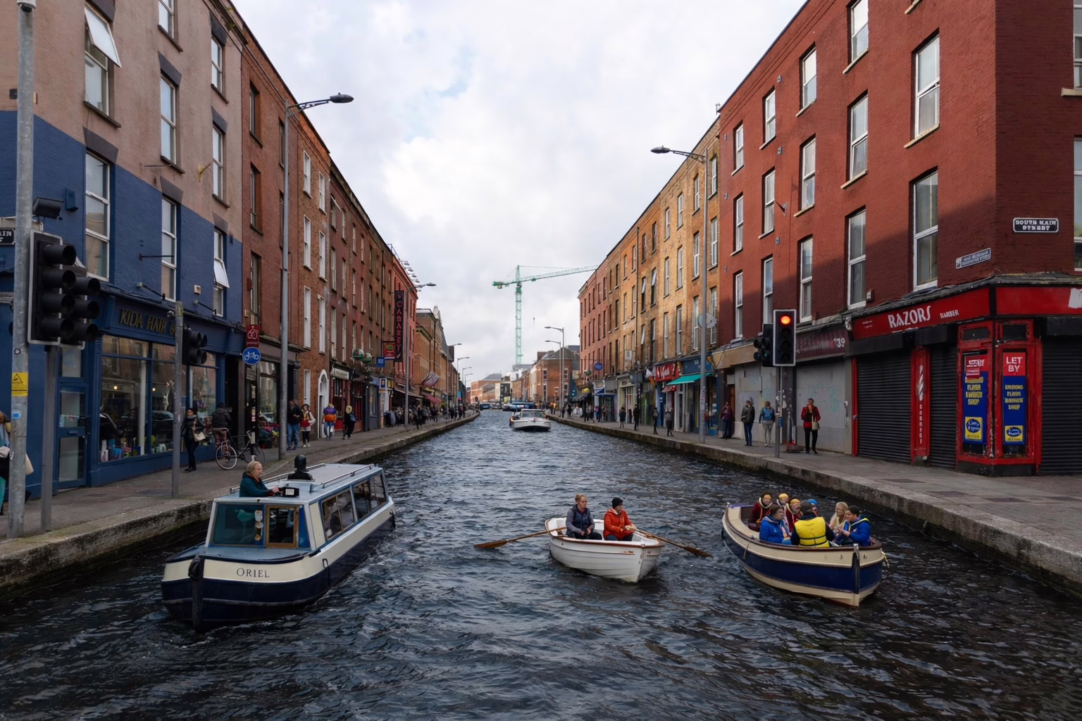 AI-manipulated photo of Washington Street in Cork city with the road replaced by a canal carrying boats including a blue narrowboat named "ORIEL", a white rowing boat, and a blue motor launch with passengers in life jackets, with shops including Kida Hair and Razors Barber visible on either side, a green construction crane in the background, and a South Main Street sign on the right.